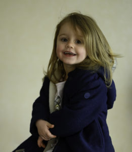 Petite fille qui fait un grand sourire en regardant l'objectif, photographe d'enfants Houilles