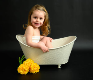 Petite fille assise dans une petite baignoire, fleurs jaunes, photographe d'enfants Houilles
