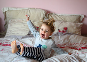 Petite fille qui saute sur le lit, figée en plein mouvement 
photographe enfant Houilles 
