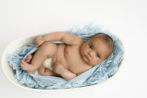Bébé emmailloté de bleu, allongé dans une petite baignoire, qui fixe l'objectif
Photographe bébé Houilles 
Photographe naissance Houilles
Photographe nouveau-né Houilles
Photographe Houilles