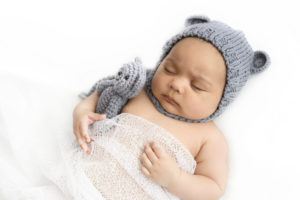 Bébé avec un bonnet en laine gris et un doudou assorti endormi sur le dos sur un beanbag blanc
Photographe bébé Houilles 
Photographe naissance Houilles
Photographe nouveau-né Houilles
Photographe Houilles