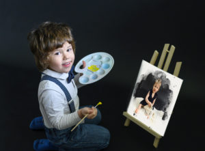 Petit garçon en train de peindre une aquarelle représentant sa petite soeur sur un petit chevalet. 
Photographe enfants Houilles, photographe Houilles, photographe bébé Houilles, photographe nouveau-né Houilles, photographe grossesse Houilles