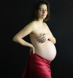 Femme enceinte voile en soie rouge autour de la taille main poitrine, photographe de grossesse Houilles Photographe grossesse Houilles Photographe maternité Houilles Photographe Houilles