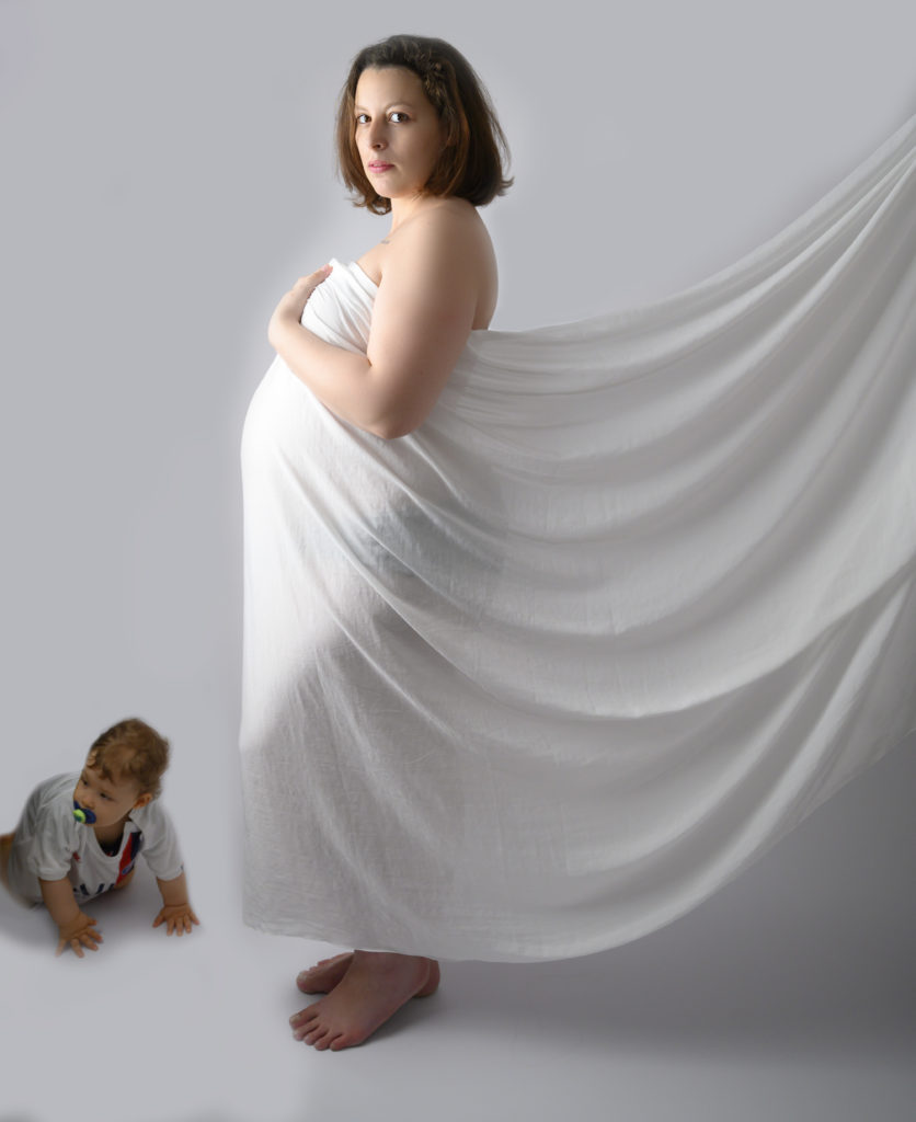 Femme enceinte voile de soie blanche et bébé à quatre pattes qui arrive sur la photo 
Photographe grossesse Houilles photographe maternité Houilles photographe Houilles 