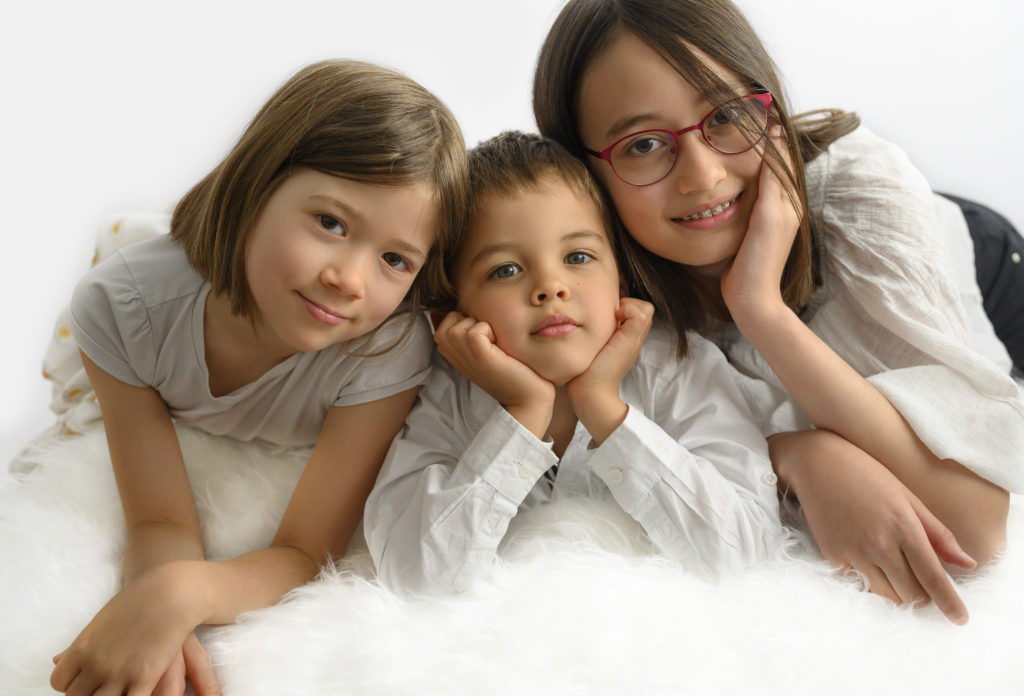 deux soeurs encadrent leur petit frère à plat ventre sur une couverture blanche
photographe enfants Houilles
photographe famille Houilles
photographe Houilles