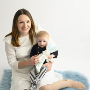 femme assise sur un tapis bleu avec son bébé dans les bras photographe famille Houilles photographe bébé houilles photographe Houilles