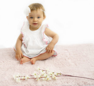 Bébé fille en robe  blanche et headband fleuri assise sur un flokati blanc 
Photographe bébé Houilles
Photographe Houilles 
