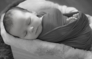 bébé emmailloté endormi dans une caisse photographe naissance houilles photographe nouveau-né houilles