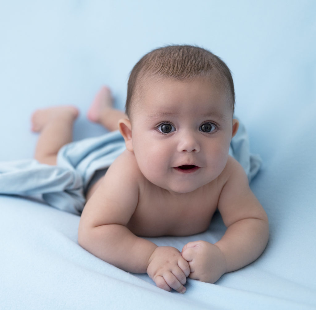 bébé de 3 mois en appui sur ses bras wrap bleu sur fond bleu photographe bébé Houilles photographe Houilles