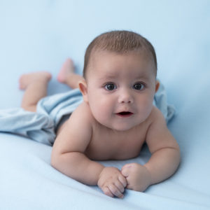bébé de 3 mois en appui sur ses bras wrap bleu sur fond bleu photographe bébé Houilles photographe Houilles