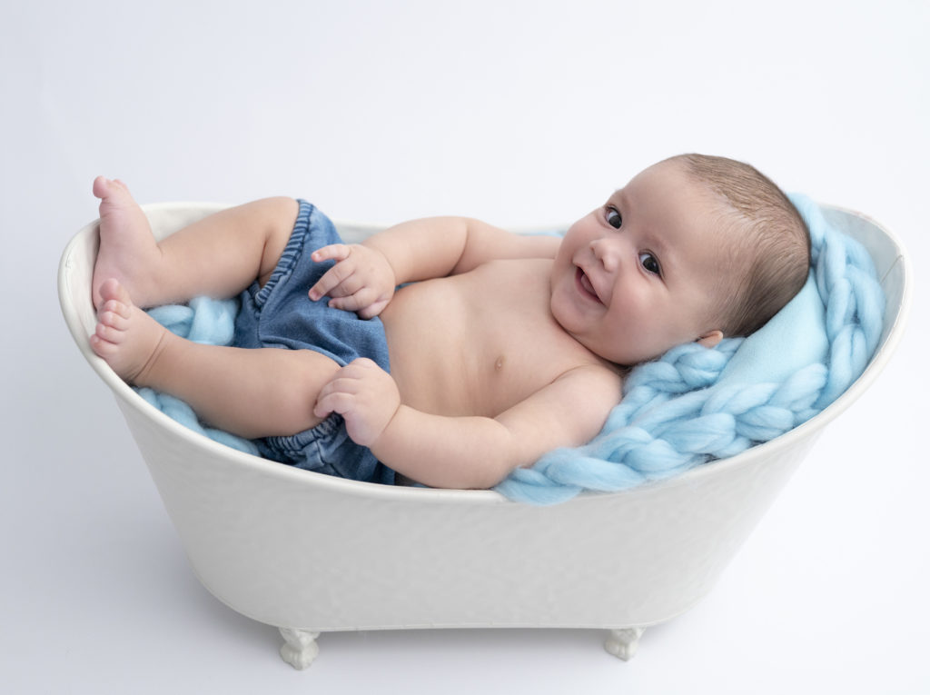 bébé de trois mois installé dans une mini baignoire qui sourit. Photographe bébé Houilles photographe nouveau-né Houilles séance photo naissance Houilles séance photo bébé Houilles photographe Houilles