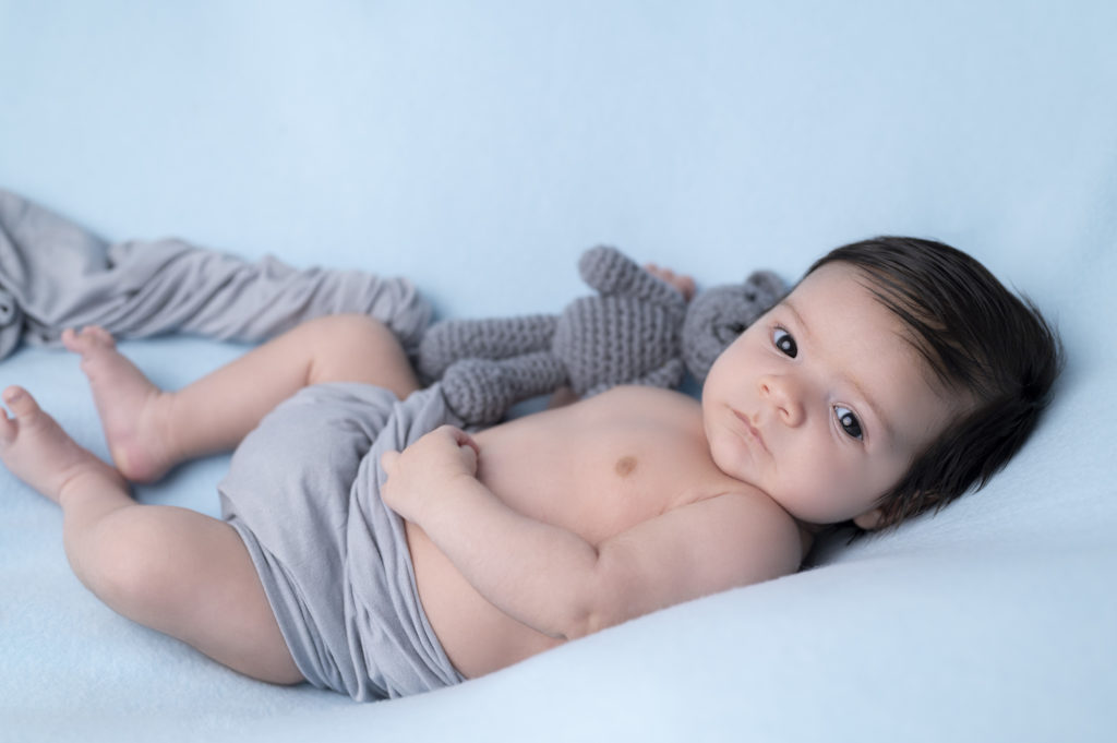 bébé allongé sur un beanbag bleu wrap et nounours gris 
photographe naissance nouveau-né houilles yvelines la défense
