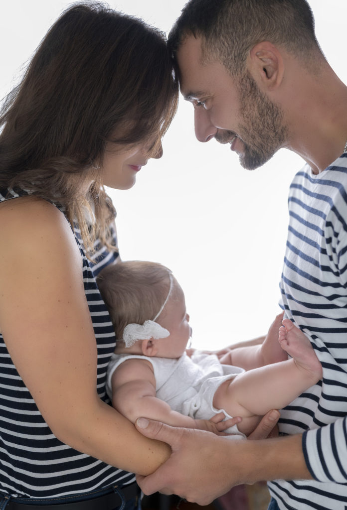 Jeunes parents en contrejour tenant leur bébé dans les bras
photographe bébé famille Houilles Yvelines