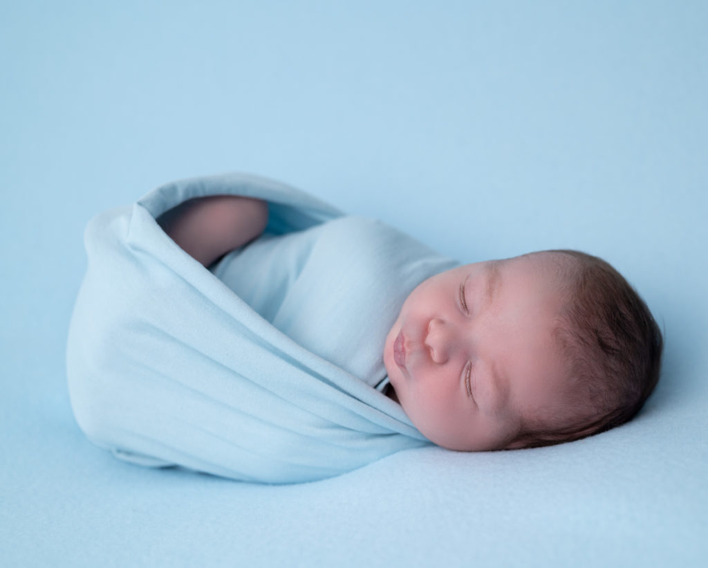 nouveau-né emmailloté de bleu endormi sur beanbag bleu photographe naissance nouveau-né Houilles Yvelines la Défense