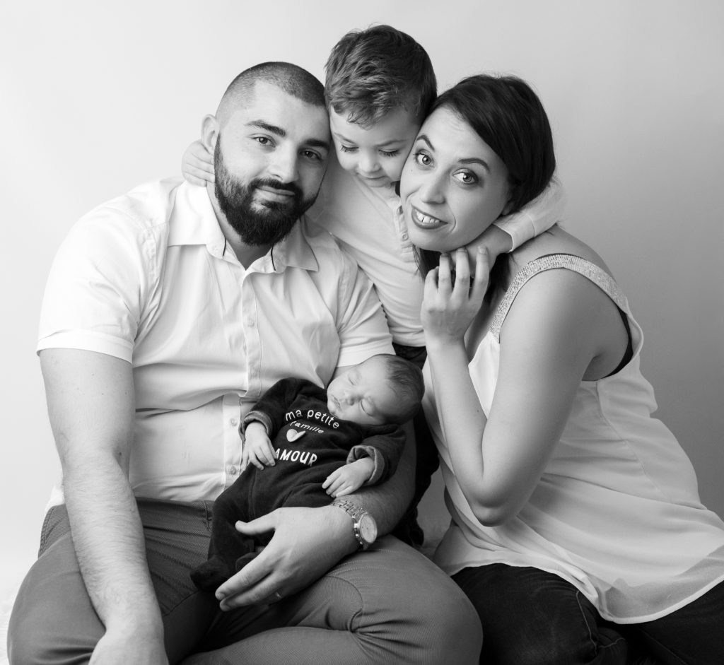 portrait noir et blanc d'une famille entourant un nouveau-né de 11 jours et un petit garçon de trois ans photographe naissance nouveau-né Houilles Yvelines la Défense
