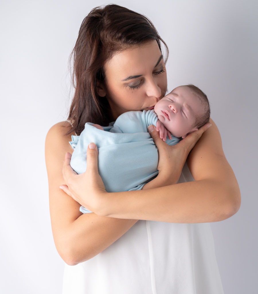 jeune maman tenant son bébé emmailloté endormi dans ses bras photographe naissance nouveau-né bébé Houilles Yvelines la Défense