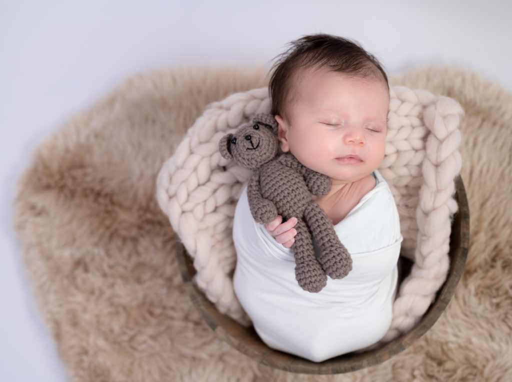 nouveau-né endormi dans une terrine ronde tenant un nounours photographe naissance nouveau-né Houilles Yvelines la Défense