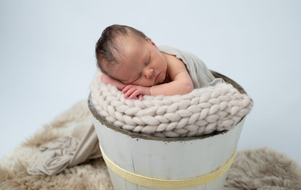 bébé endormie dans seau en bois photographe naissance nouveau-né houilles yvelines la défense