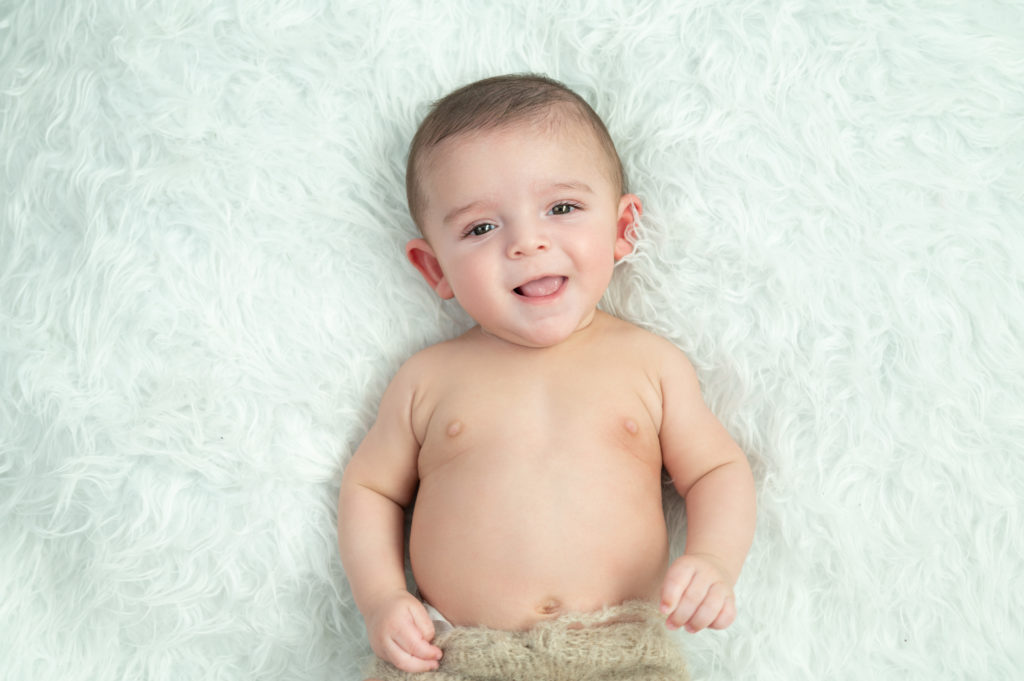 bébé de 5 mois allongé sur le dos grand sourire  photographe bébé Houilles photographe bébé la Défense photographe bébé Yvelines photographe bébé