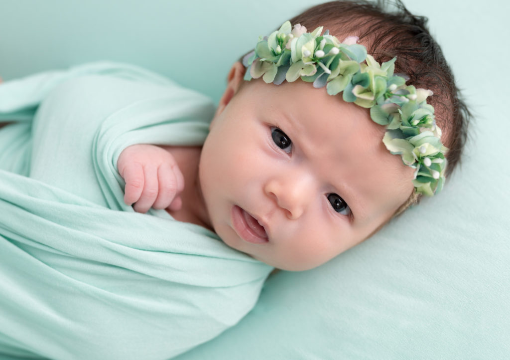 nouveau-né de 6 semaines allongé sur posing bag vert menthe regard objectif photographe naissance nouveau-né Houilles Yvelines la Défense