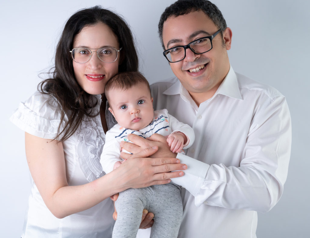 Bébé de quatre mois dans les bras de ses parents photographe bébé famille Houilles Yvelines la Défense