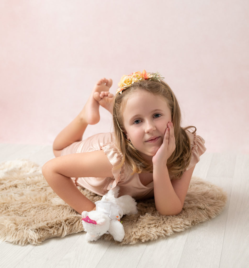 petite fille bandeau fleuri à plat ventre sur tapis en fourrure photographe enfant Houilles Yvelines la Défense