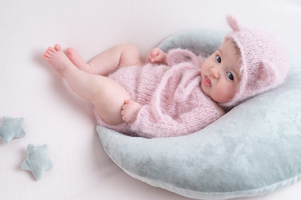 bébé en tenue rose laine doudou allongée sur posing bag rose pâle sur une lune grise photographe bébé Houilles Yvelines la Défense
