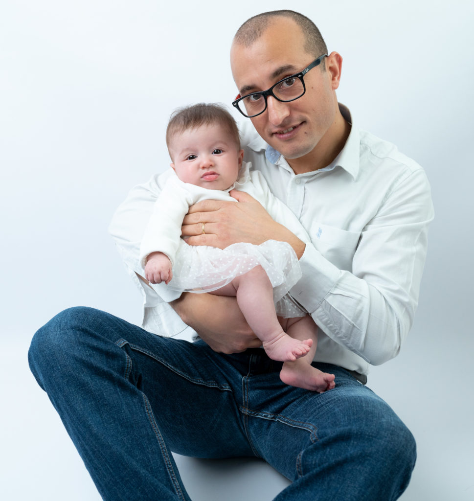 bébé de trois mois dans les bras de son papa 
photographe bébé famille Houilles Yvelines la Défense