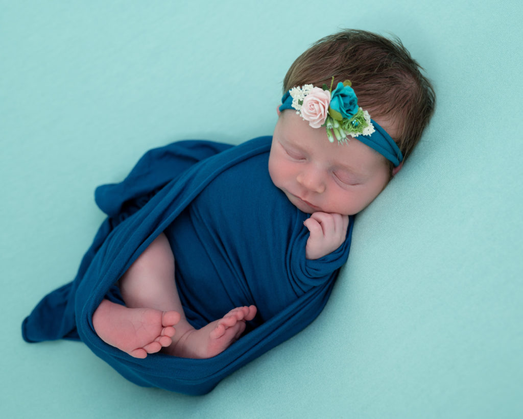 nouvelle née de 15 jours emmaillotée de bleu endormie sur fond vert menthe photographe naissance nouveau-né Houilles Yvelines la Défense