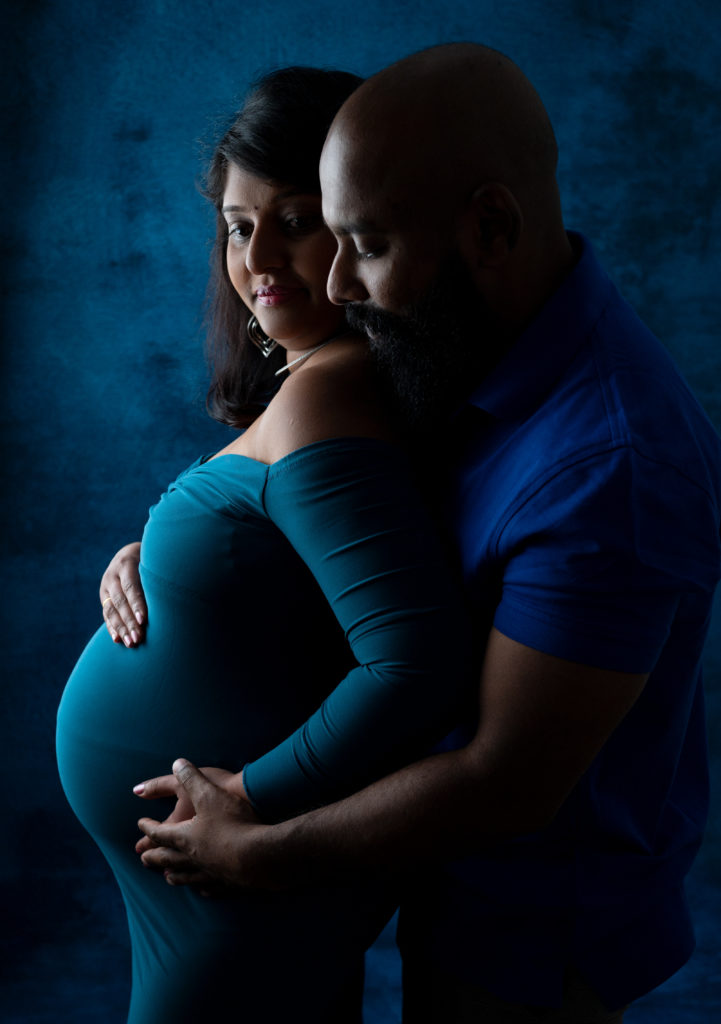 couple de futurs parents sur fond bleu photographe grossesse maternité femme enceinte Houilles Yvelines la Défense