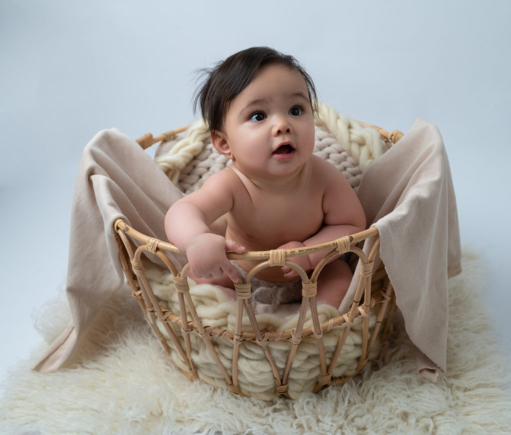 bébé de huit mois dans un panier sur beige tons naturels photographe bébé Houilles Yvelines la Défense