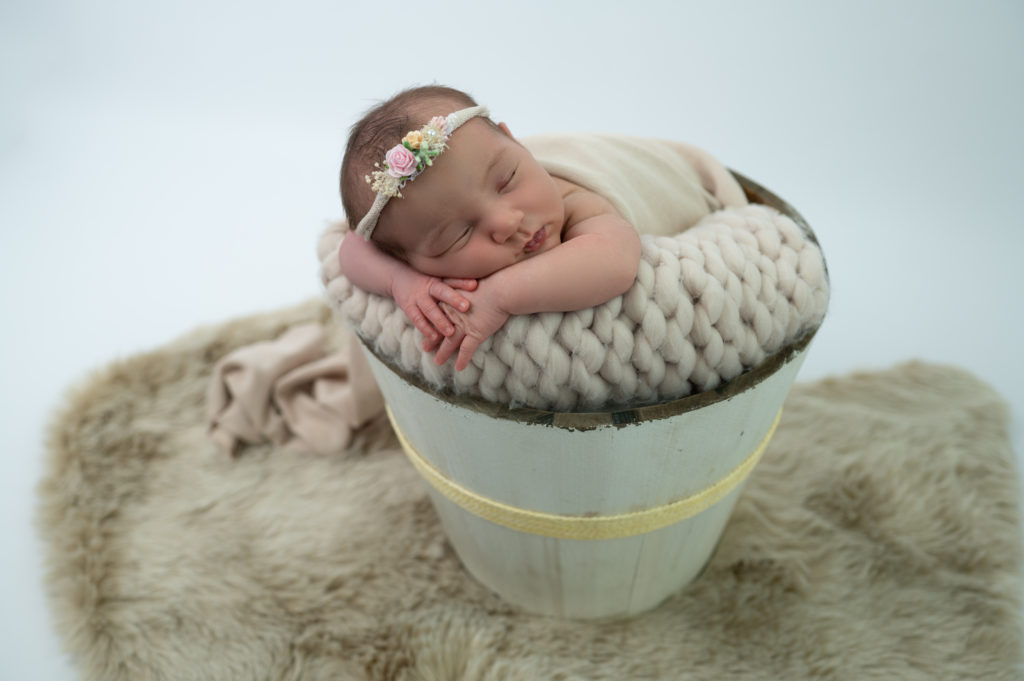 nouvelle-née endormie dans un seau en bois photographe naissance