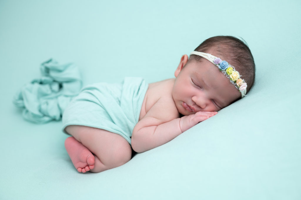 nouvelle-née emmaillotée de vert endormie sur posing bag en pose bumup photographe naissance nouveau-né bébé Houilles Yvelines la Défense