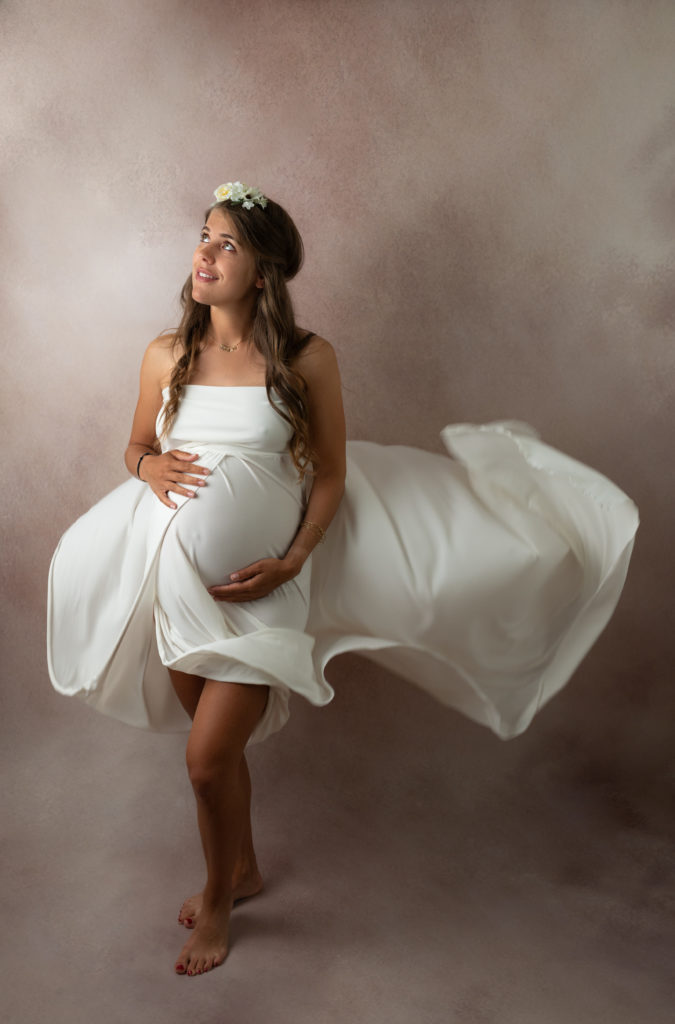 Femme enceinte robe blanche qui vole fleurs dans les cheveux photographe grossesse maternité femme enceinte Houilles Yvelines la Défense
