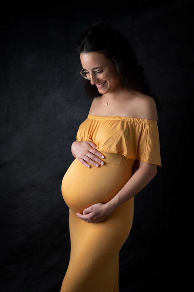 Femme enceinte robe jaune sur fond noir photographe grossesse femme enceinte Houilles Yvelines la Défense