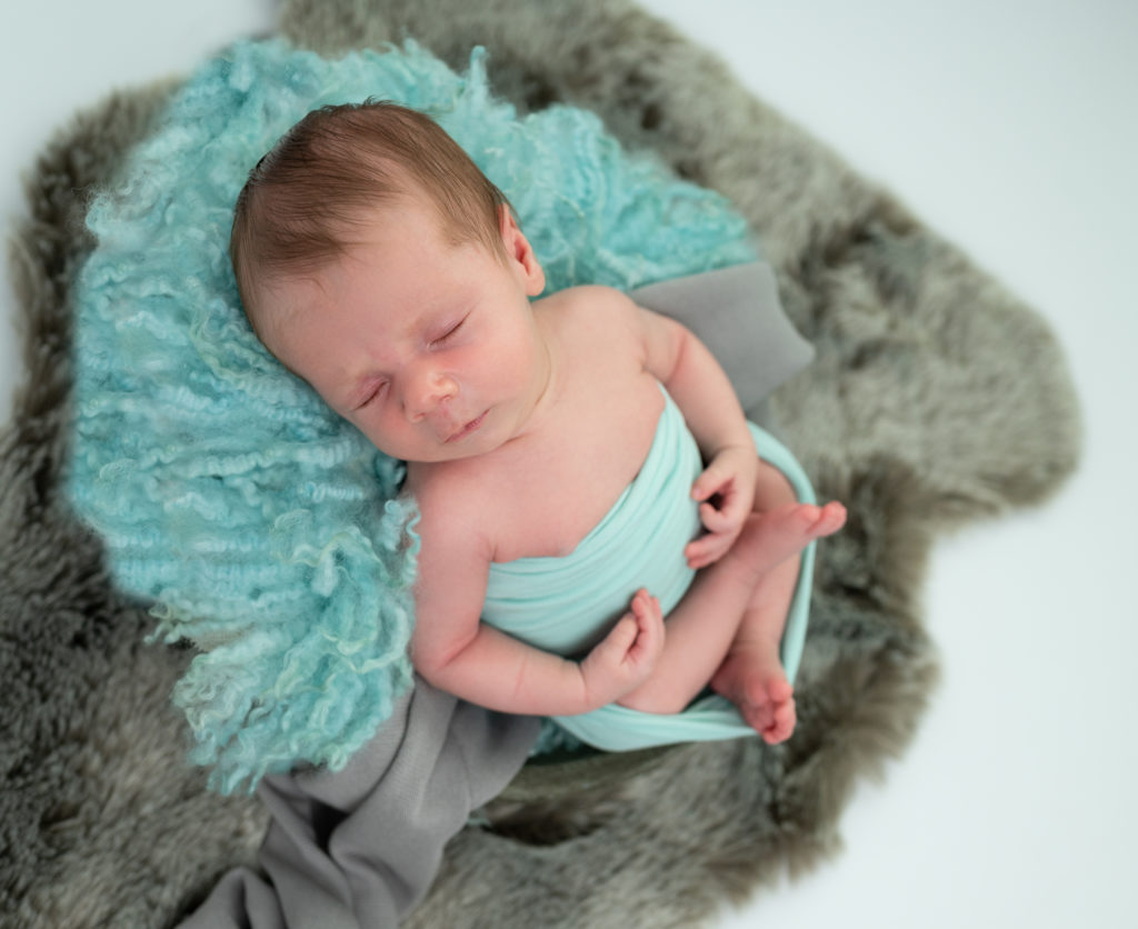 nouveau-né emmailloté endormi dans une terrine sur un fluffy vert menthe photographe naissance nouveau-né Houilles Yvelines la Défense