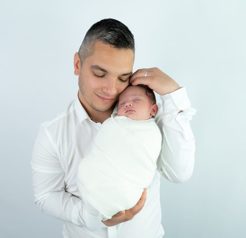 nouvelle-née endormie dans les bras de son papa photographe naissance famille Houilles Yvelines la Défense