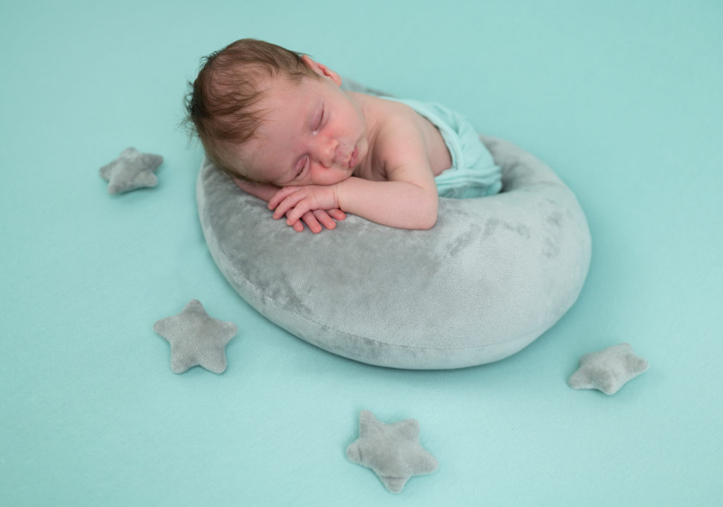 nouveau-né endormi sur posing bag vert menthe avec une lune et des étoiles grises photographe naissance nouveau-né Houilles Yvelines la Défense