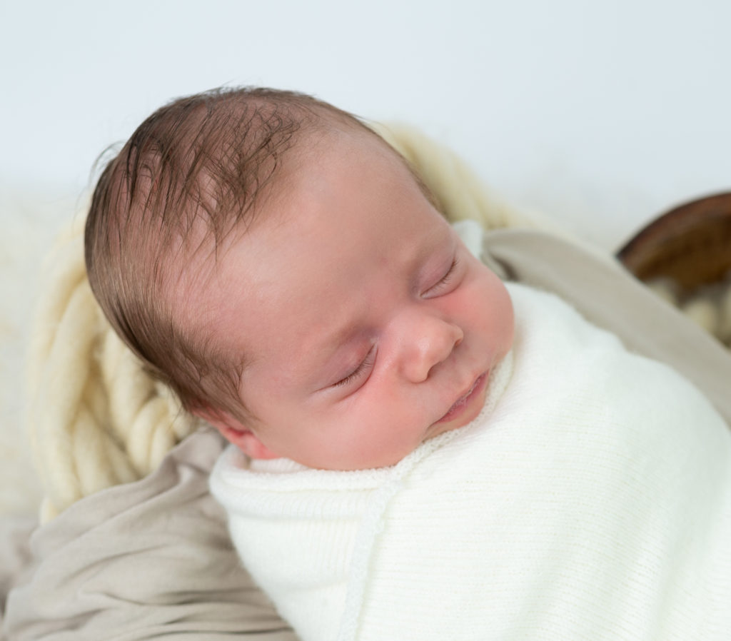 nouveau-né emmailloté de blanc endormi dans un coeur en bois photographe naissance nouveau-né Houilles Yvelines la Défense