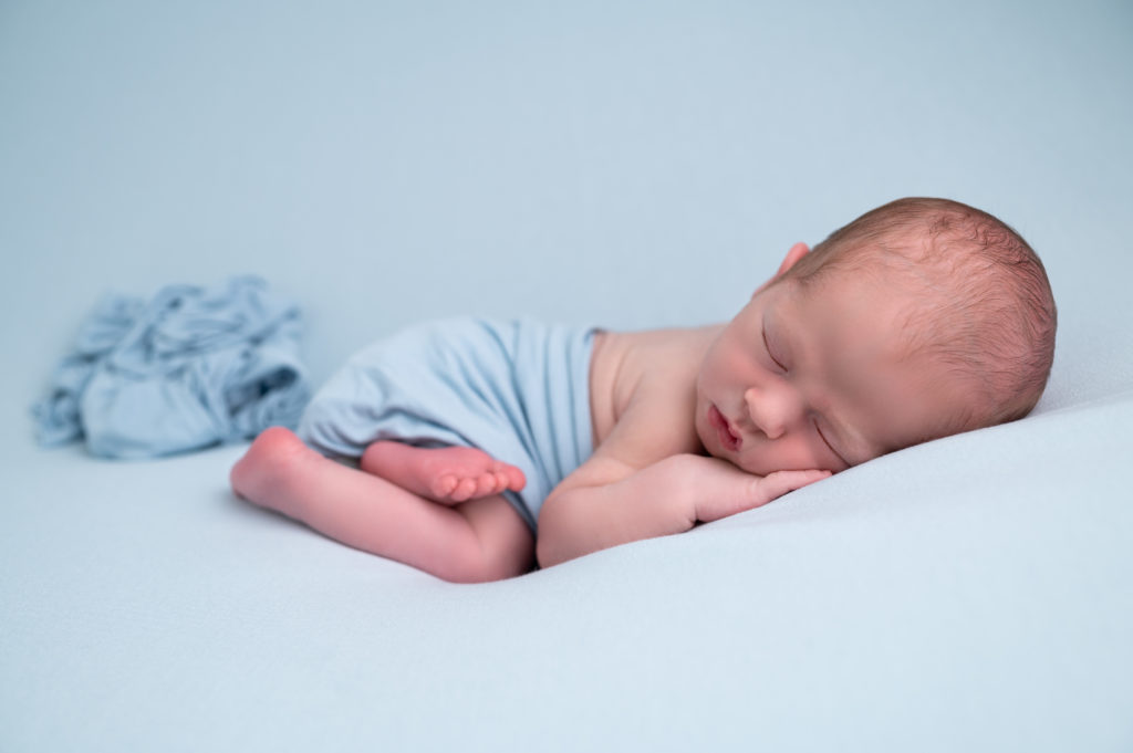 nouveau-né wrap bleu endormi sur posing bag bleu photographe naissance nouveau-né Houilles Yvelines la Défense