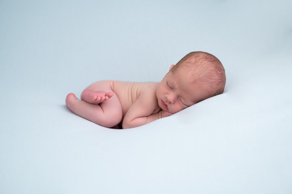 Nouveau-né endormi en pose bumup sur posing bag bleu photographe naissance nouveau-né Houilles Yvelines la Défense