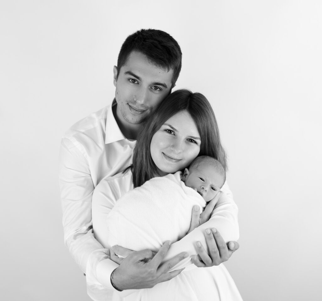 jeunes parents tenant leur nouveau-né dans les bras photographe naissance bébé famille Houilles Yvelines la Défense