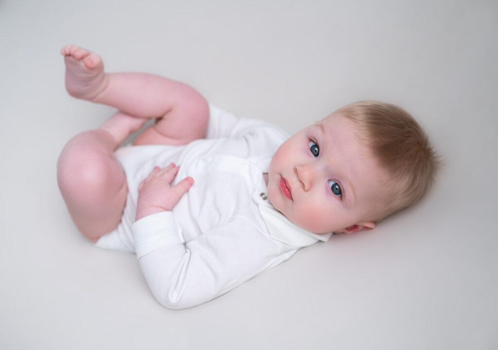 bébé de 6 mois allongé sur posing bag beige photographe bébé Houilles photographe bébé Yvelines photographe bébé la Défense