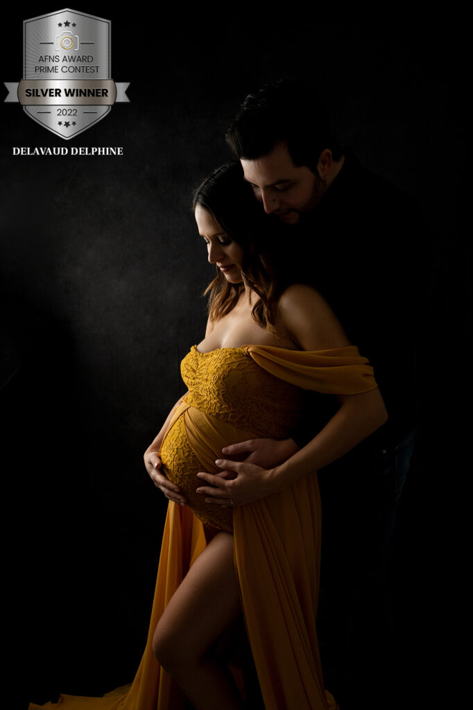 Couple de futurs parents sur fond noir regardant bébé photographe grossesse Houilles photographe grossesse la Défense photographe grossesse Yvelines photographe grossesse Hauts de Seine