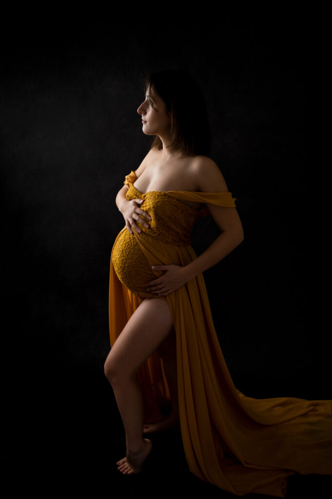 Femme enceinte robe jaune moutarde sur fond noir photographe grossesse Houilles photographe grossesse la Défense photographe grossesse Versailles photographe grossesse Yvelines photographe grossesse Hauts de Seine