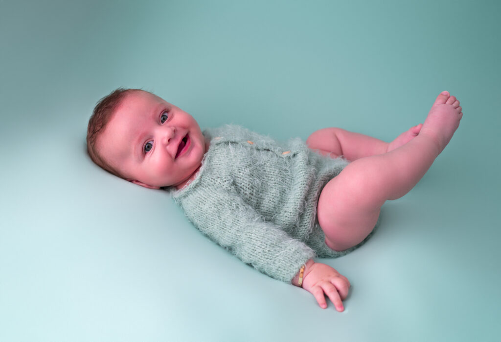 Bébé de trois mois allongée sur le ventre fond vert photographe bébé Houilles photographe bébé Yvelines photographe bébé Versailles photographe bébé Ile de France photographe bébé Paris