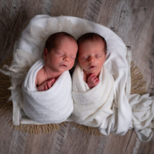 Jumeaux nouveaux-nés emmaillotés de blanc endormis dans une caisse photographe naissance houilles photographe naissance yvelines photographe naissance ile de france photographe naissance paris
