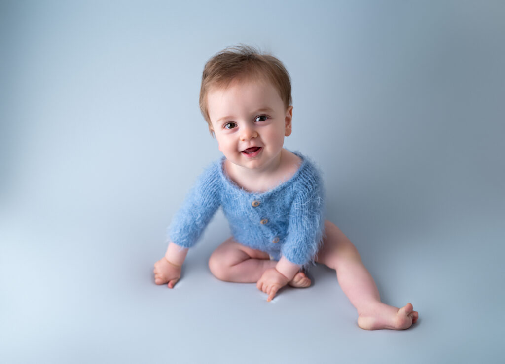 bébé de 10 mois body en laine bleu dressing virtuel des bébés photographe bébé Houilles photographe bébé la Défense photographe bébé Versailles photographe bébé Ile de France photographe bébé Hauts de Seine photographe bébé Yvelines photographe bébé Val d'Oise