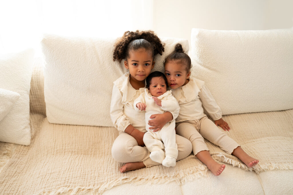 Petites filles avec leur toute petite soeur nouveau-né à leur domicile photographe naissance Houilles photographe naissance à domicile photographe naissance yvelines photographe naissance hauts de seine photographe naissance ile de france photographe naissance val d'oise photographe naissance paris