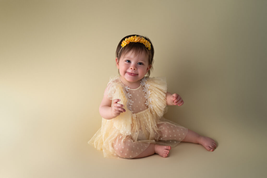 Petite fille de un an sur fond jaune photographe smash the cake Houilles Séance Smash the Cake à Houilles / Yvelines – Delphine Delavaud Photographie